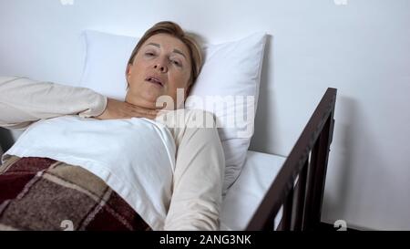 Femmina malato nel letto a malapena respirando, sofferenza soffocamento, la malattia dell'asma Foto Stock