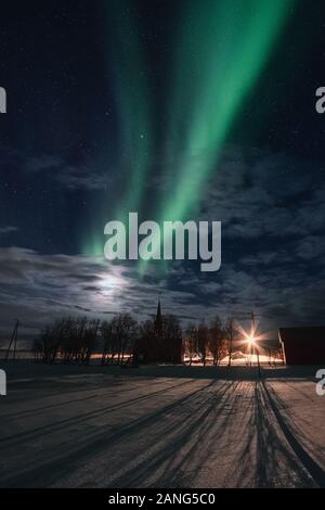 Luci del nord, aurora boreale con stellato nel cielo notturno su Flakstad chiesa nelle Isole Lofoten in Norvegia Foto Stock