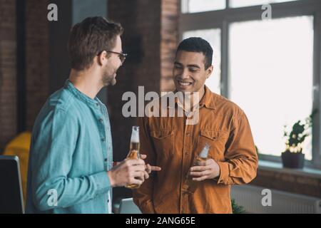 Felice positivo giovani amici bere birre insieme Foto Stock