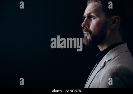 Bello Brunet uomo barbuto in giacca leggera Vista laterale Foto Stock