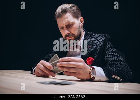 Uomo Barbuto con il filtro Bow Tie Controllo Mano di Poker Foto Stock