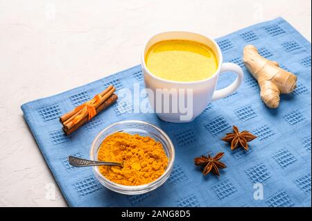 Tazza di tradizionale indiano Masala chai tè con gli ingredienti sopra in bianco sullo sfondo di texture Foto Stock