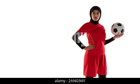 Arabian calcio femminile o giocatore di football isolato su bianco di sfondo per studio. Giovane donna tenendo la palla, formazione in movimento, l'azione. Concetto di sport, hobby, uno stile di vita sano. Flyer, flysheet. Foto Stock