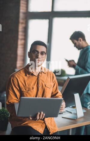 Intelligent uomo bello avente il suo laptop in mani Foto Stock