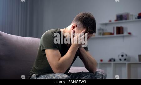 Premuto soldato piangendo a casa, ricordandosi di morti di borsisti e gli orrori della guerra Foto Stock