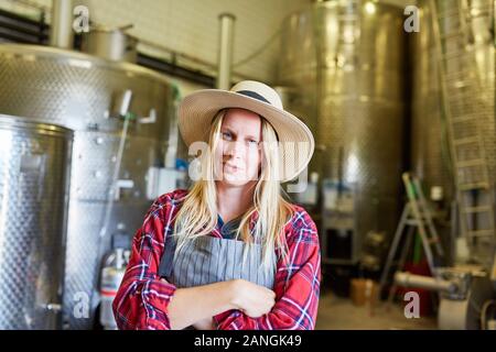 Giovane donna come un enologo o produttore di birra in una cantina o la fabbrica di birra Foto Stock