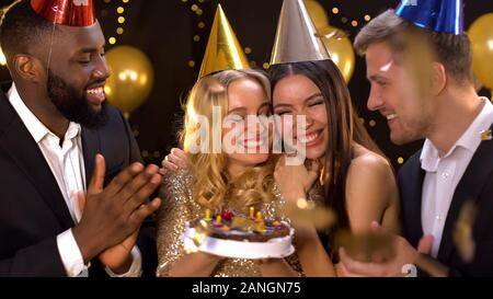 Bellissima femmina festeggia il compleanno, tenendo la torta, amici congratulazioni Foto Stock