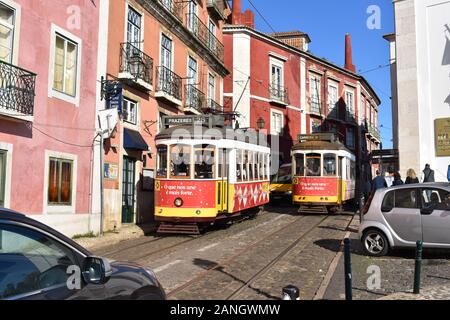 Tram che passano l'un l'altro nel quartiere di Alfama, Lisbona, Portogallo Foto Stock