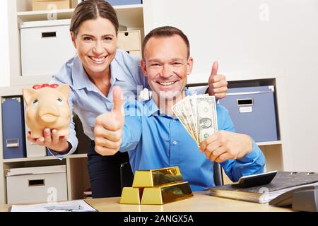 I consulenti finanziari con oro e denaro tenere le dita incrociate in ufficio Foto Stock