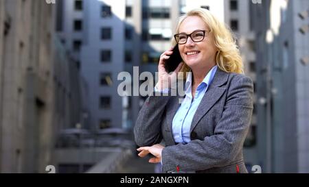 Happy business Donna che parla al telefono in piedi al di fuori di una buona notizia e motivazione Foto Stock