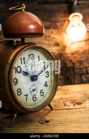 Il vecchio orologio sveglia con lampadina incandescente - close up Foto Stock