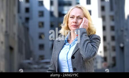 Sottolineato lavoratore di ufficio sensazione di cefalea tempio di massaggio, health care, pressione Foto Stock
