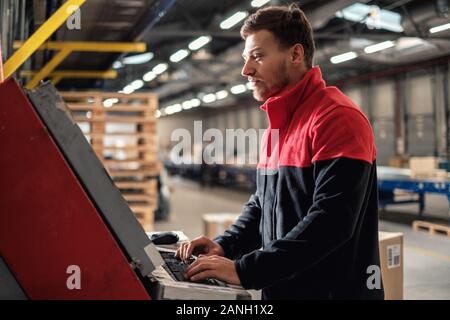 Corriere preleva il pacchetto su un magazzino Foto Stock