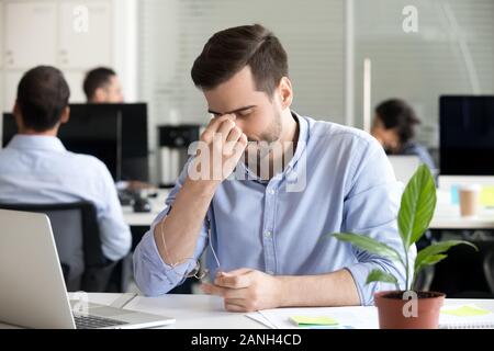 Esaurito lavoratore maschile togliere gli occhiali gli occhi di massaggio avente tensione oculare o del ceppo funziona troppo a lungo con il computer, stanco uomo soffre di mal di testa o b Foto Stock