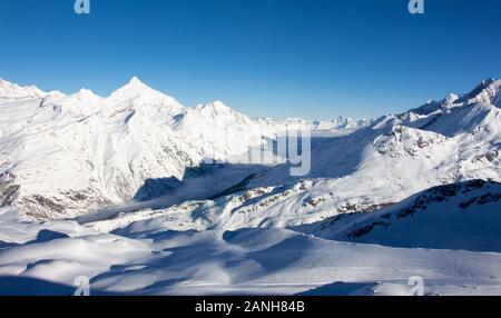 Importa la valle e le montagne nevose vista al tramonto paesaggio invernale sulle Alpi Svizzere nuvole di luce nella valle Foto Stock