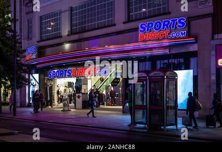 Luminosa e incandescente segni al di fuori di un Sport Direct.com store su Oxford Street, Londra, Inghilterra, Regno Unito. Foto Stock