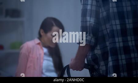 Il marito a compierli cintura di contenimento, minacciando moglie, violenza domestica vittima, diritti Foto Stock