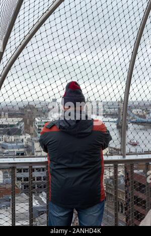 Lone maschio turista alla piattaforma di osservazione Monument London godendo la vista sul Tamigi e scattando foto del Tower Bridge, Londra, Regno Unito Foto Stock