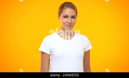 Giovane e bella donna che guarda interessato fotocamera, bellezza naturale, di fiducia Foto Stock