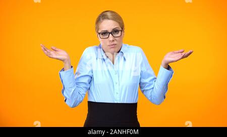 Confuso business lady alzare le mani, non avente alcuna idea, mancanza di ispirazione Foto Stock