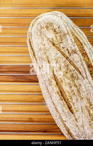 Pane appena sfornato white pagnotta di pane su una griglia di raffreddamento e tagliere di legno Foto Stock