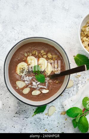 Frullato al cioccolato ciotola e rabboccato con frutti e semi/ colazione sana nozione Foto Stock