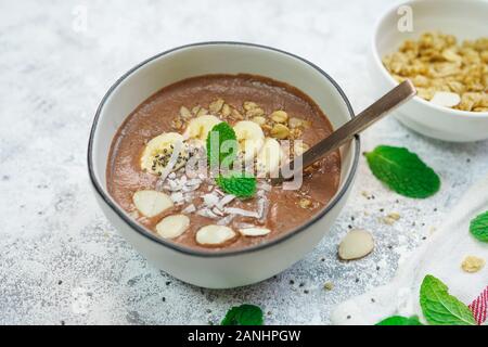 Frullato al cioccolato ciotola e rabboccato con frutti e semi/ colazione sana nozione Foto Stock