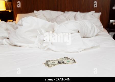 Suggerimenti sul letto disfatto in hotel per il personale. Due dollari su lenzuola Foto Stock