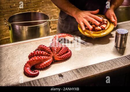 Stile galiziano bollito di Squid Octopus essendo preparato in uno dei ristoranti tradizionali in Melide, Spagna Foto Stock