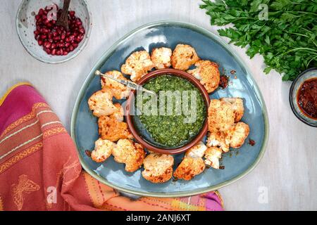 Cibo Vegan con mezzo di sapori orientali: Harissa cavolfiore con Pesto Corriander Foto Stock