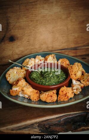 Cibo Vegan con mezzo di sapori orientali: Harissa cavolfiore con Pesto Corriander Foto Stock