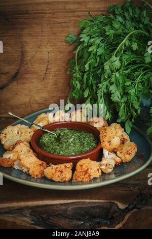 Cibo Vegan con mezzo di sapori orientali: Harissa cavolfiore con Pesto Corriander Foto Stock