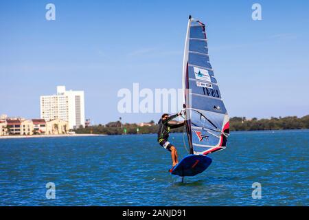 Un windsurf vola fuori dell'acqua nella parte anteriore del Ponte di Causeway nel porto di Clearwater. La temperatura è aumentata nella 80's impostazione vicino ad alta record per questo tempo di anno in Florida. Foto Stock