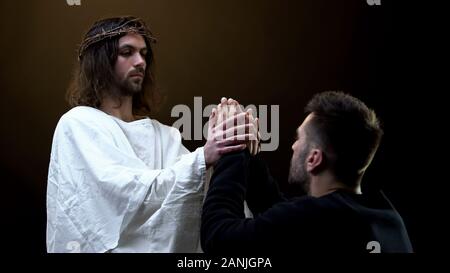 Gesù Cristo per mano di orante, assistenza religiosa, peccati perdono Foto Stock