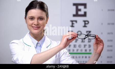 Donna sorridente oculista consigliare occhiali, correzione della vista Foto Stock