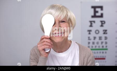 Ritirato femmina occhio di chiusura e sorridente alla telecamera e di successo della chirurgia della cataratta Foto Stock