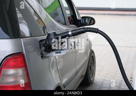 Auto riempire con benzina a gas station. Close up di pompaggio del carburante benzina in grigio auto presso la stazione di gas. Foto Stock