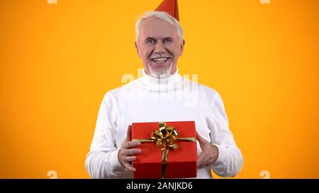 Allegro uomo anziano azienda confezione regalo, presente da vicino la gente, di felicità Foto Stock