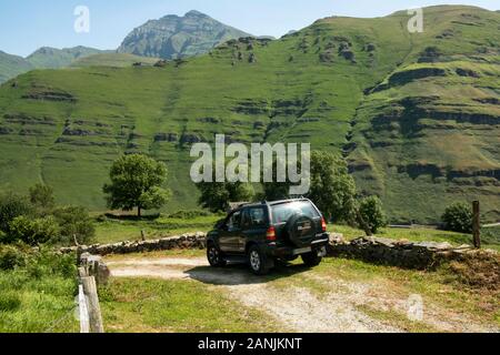 Opel Frontera fuoristrada verde laning nella valle di Yera con la vetta di Castro Valnera all'estremo (Vega de Pas, Valles Pasiegos, Cantabria, Spagna) Foto Stock