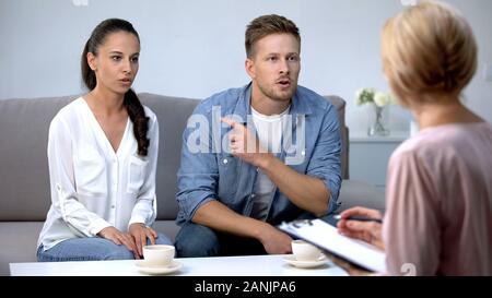 Giovane sostenendo alla sessione di terapia con lo psicologo, famiglia incomprensione Foto Stock