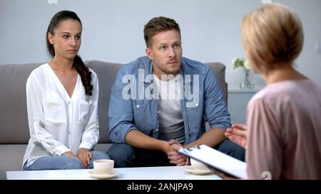 Coppia giovane ascoltando la sconvolgente notizia di psicologo, problema di relazioni Foto Stock
