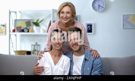 Madre-in-legge abbracciando il figlio e sua moglie, famiglia felice concetto di relazione Foto Stock