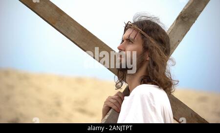 Gesù Cristo con la corona di spine che trasportano cross, pregando Dio per i peccatori Foto Stock