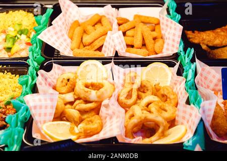 Nocivo street food. Anelli di totano pesci e formaggio bastoni panate su un caso di visualizzazione come cibo di strada. Stock Photo grassi nocivi junk food. Foto Stock