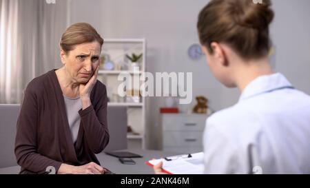 Pianto disperato old Lady ascolto medico donna discutendo la diagnosi, medicina Foto Stock
