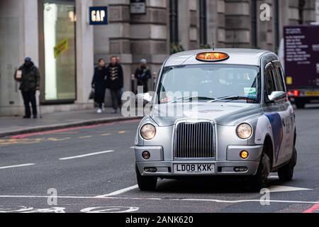 London, England, Regno Unito - 31 dicembre 2019: tipico black cab di Londra nelle strade della città. Tradizionalmente chiamato i taxi sono tutto nero a Londra ma ora prodotta Foto Stock