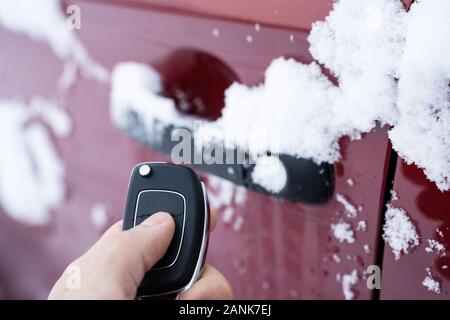 Uomo che cerca di aprire congelati porta auto con telecomando Foto Stock