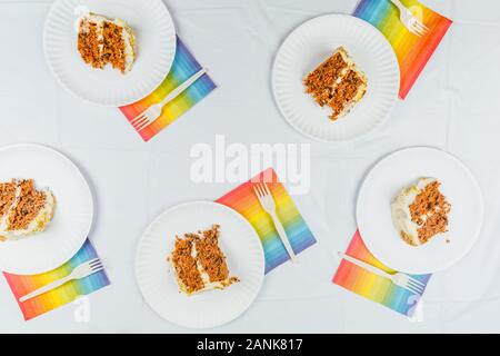 Lay piatto con la torta di compleanno di pezzi sul libro bianco le piastre. Festa di compleanno celebrazione del concetto. Posizione orizzontale Foto Stock