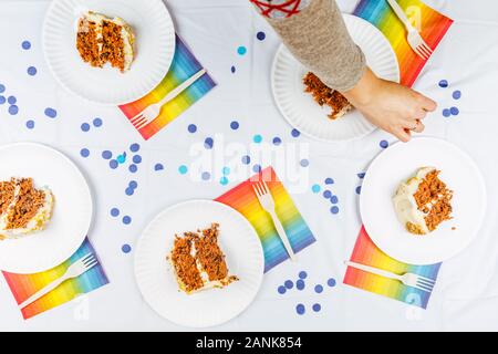 Lay piatto con la torta di compleanno di pezzi sul libro bianco le piastre. Festa di compleanno celebrazione del concetto. Posizione orizzontale Foto Stock