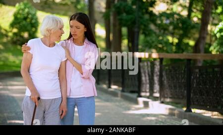 Giovane donna il supporto di malati anziana signora di bastone da passeggio, malattia depressione, rehab Foto Stock